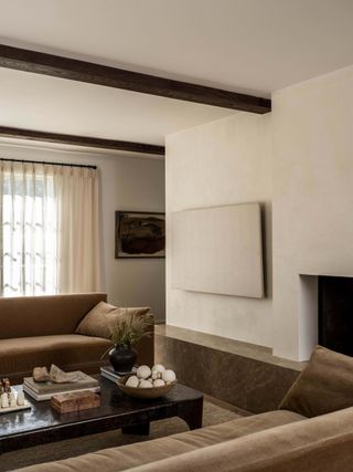 neutral living room with brown sofas and marble