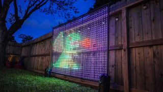 An angled shot showing a fire breathing dragon on the Govee Lightwall set up in a backyard