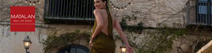Woman wearing Matalan's olive coloured backless dress walking up the stairs