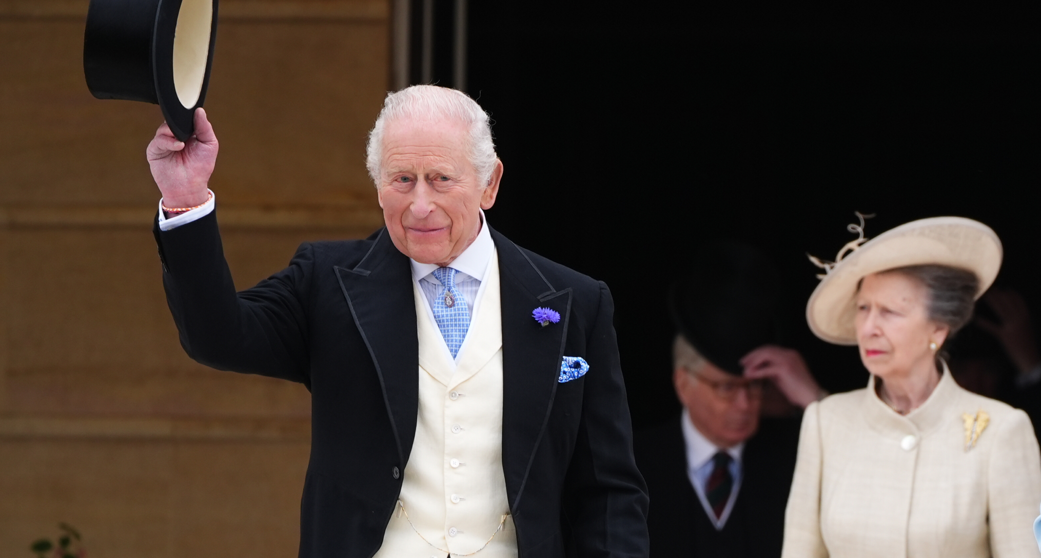 King Charles tipping his hat at a garden party