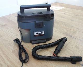 An unboxed Shark MessMaster carpet cleaner on laminate flooring