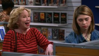 Kitty and Leia standing in the aisle of Video Haven in That '90s Show.