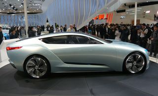 People viewing a Buick Riviera on display at a car show