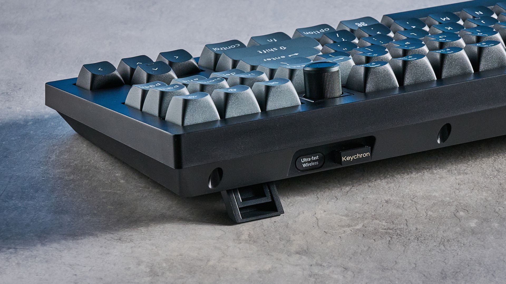 Keychron V3 Ultra 8K photographed on a grey table top in front of a blue background