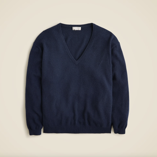 a navy Jcrew sweater in front of a plain backdrop