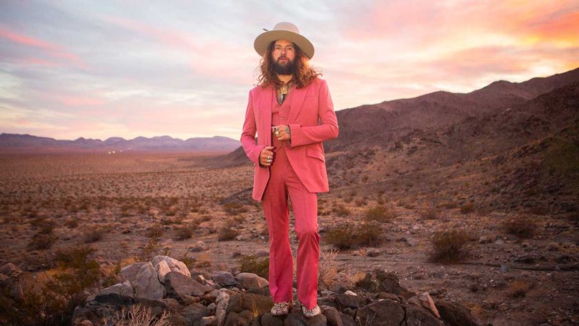 Jay Buchanan in a pink suit standing in a desert landscape