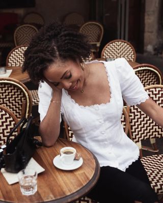 French woman wearing a white summery top