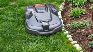 A robot lawn mower cutting the grass around the edge of the lawn