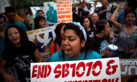 Protesters opposed to Arizona&amp;#039;s immigration law SB 1070 march through downtown Phoenix Monday: The Supreme Court ruled the state had no right to undermined federal policy on immigration.