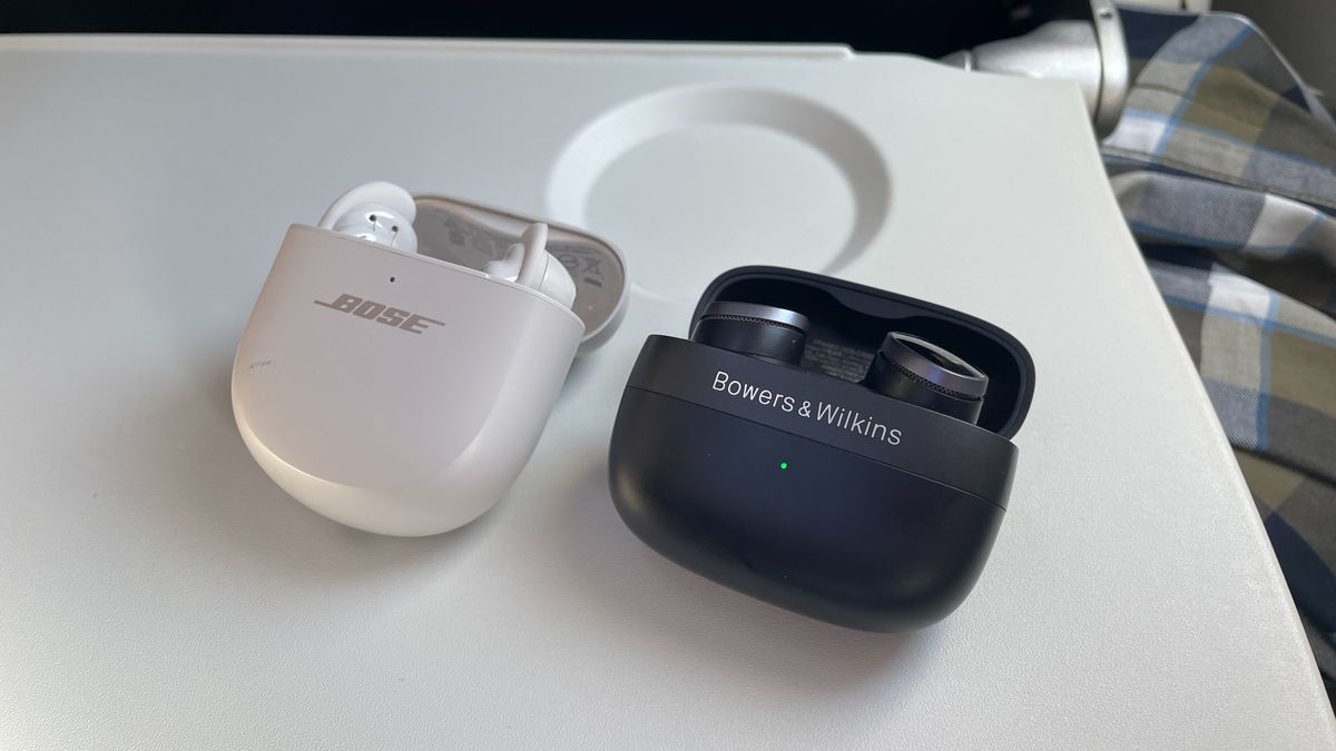 Bose QuietComfort Ultra Earbuds and Bowers Wilkins Pi8 earbuds on an aeroplane tray table 