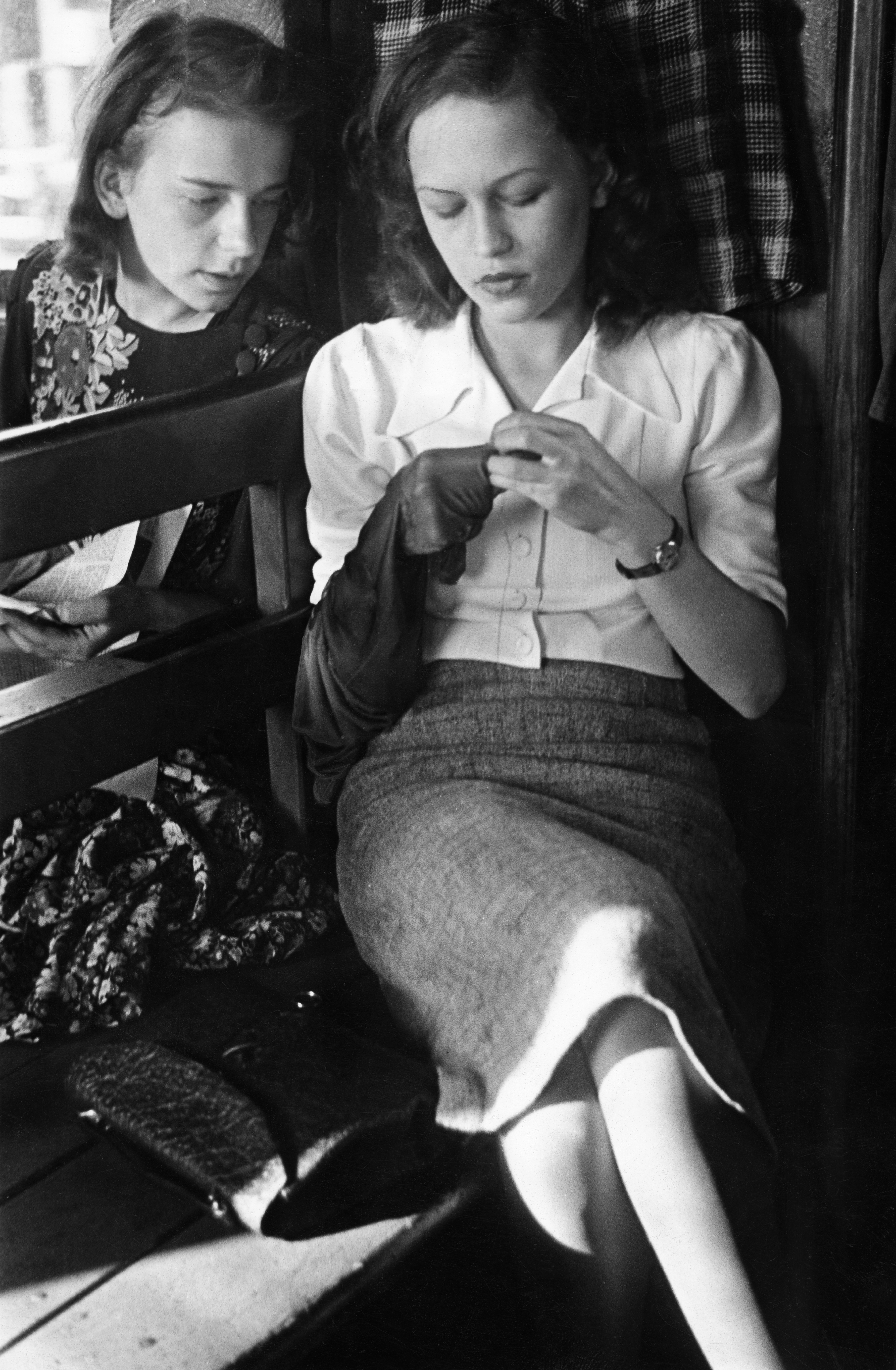 Young woman darning a pair of stockings