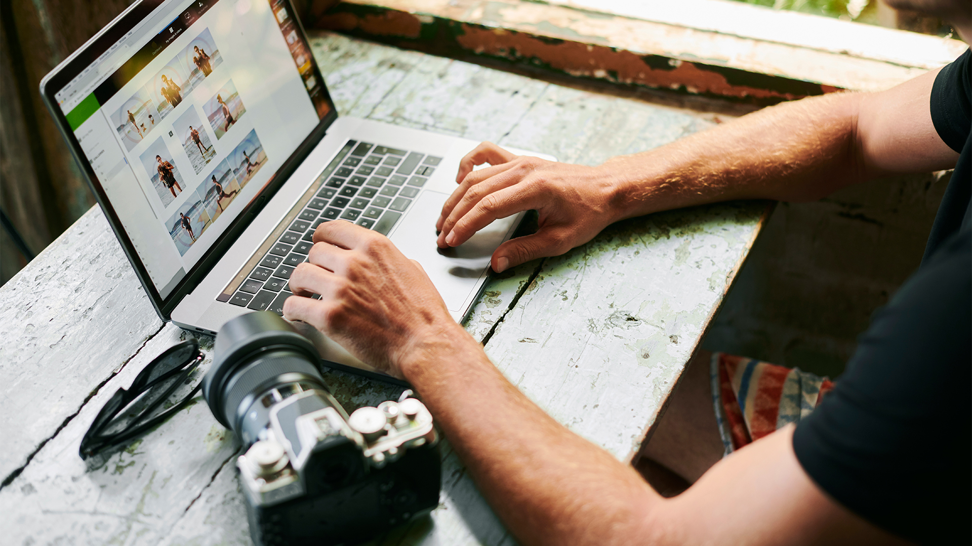 Person on their laptop with a camera placed next next to their left hand 