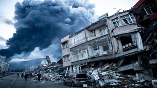 Smoke billows from a fire at the port as people inspect collapsed buildings in Iskenderun, Turkey. 