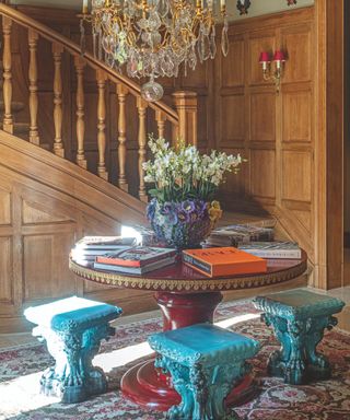 Hallway with wooden walls and round table with stools