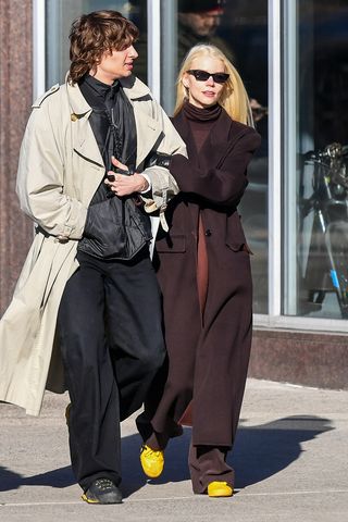 Anya Taylor-Joy wearing a burgundy outfit and yellow sneakers with husband in NYC.