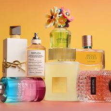 A collection of fragrances available for purchase at LOOKFANTASTIC displayed against a light orange and pink background