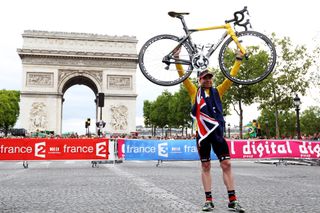 Cadel Evans holding his Tour de France bike above his head after winning the 2011 Tour de France