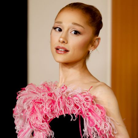 Ariana Grande wearing a bun hairstyle and looking at the camera