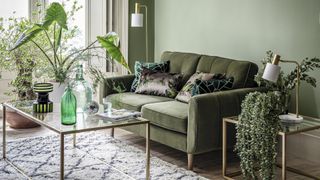 Sage green living room with fern green velvet sofa and brushed brass coffee table and lamps