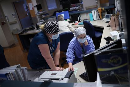 Health care workers in a Maryland hospital look at their computer.