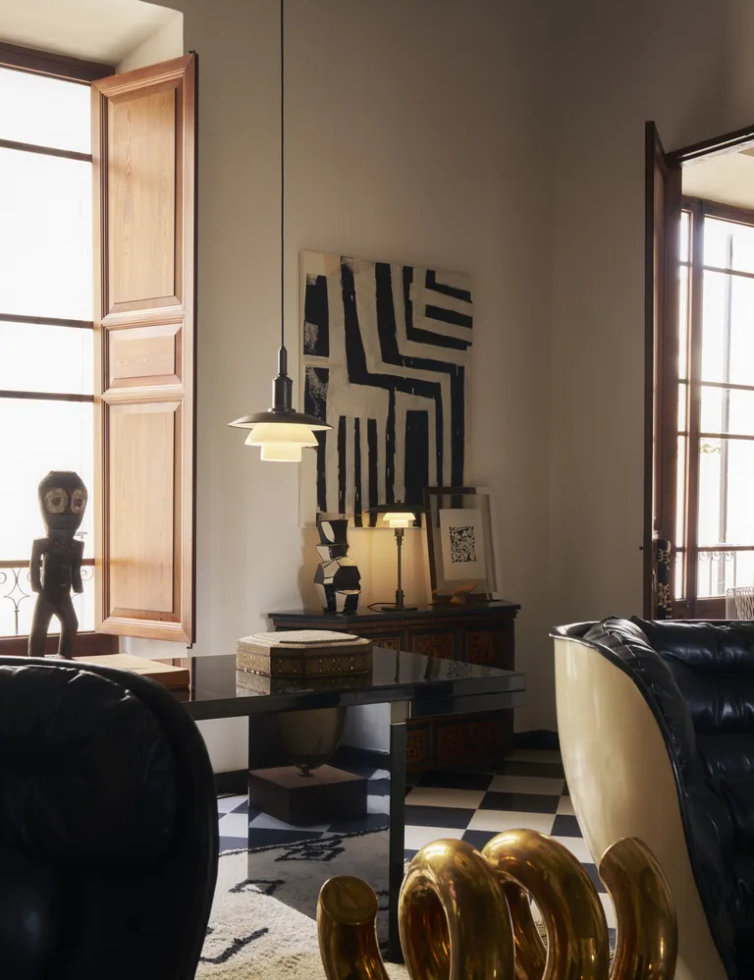 Louis Poulsen tiered pendant and table lights pictured in an eclectic, art-forward living room