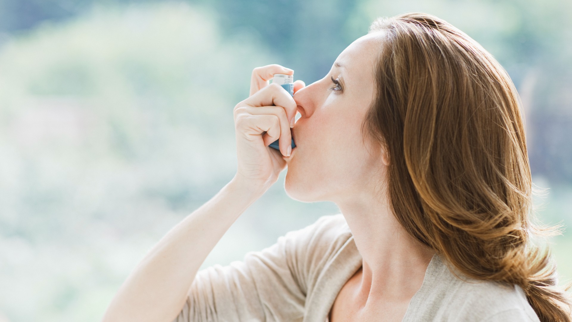 Femme à l'aide d'un inhalateur pour l'asthme