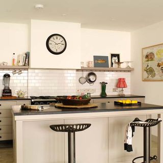 kitchen with white wall and black countertop and vintage tractor seats