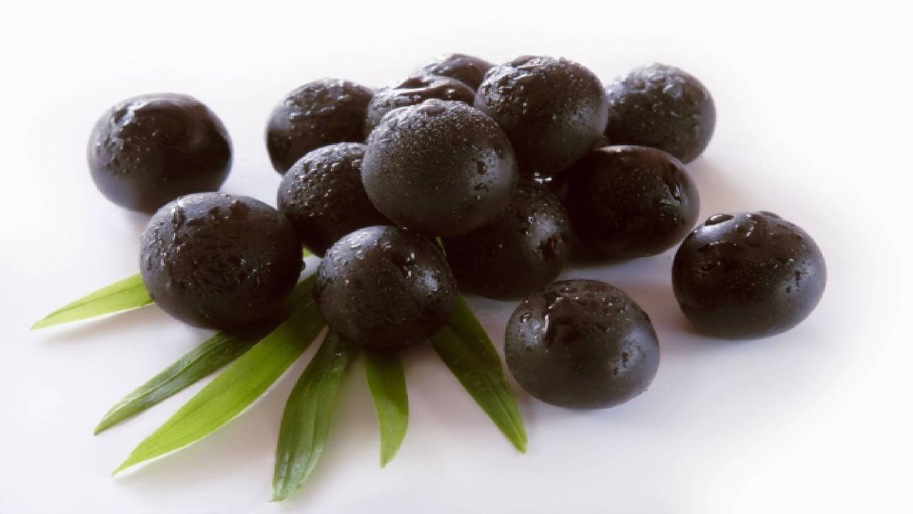 picture of a bunch of açai berries on white foreground