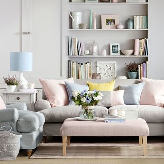 Living room shelving ideas with grey shelves and cupboards and pink footstool