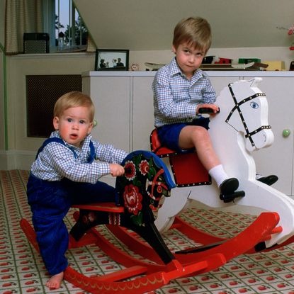 Prince William and Prince Harry on rocking horses in their play room