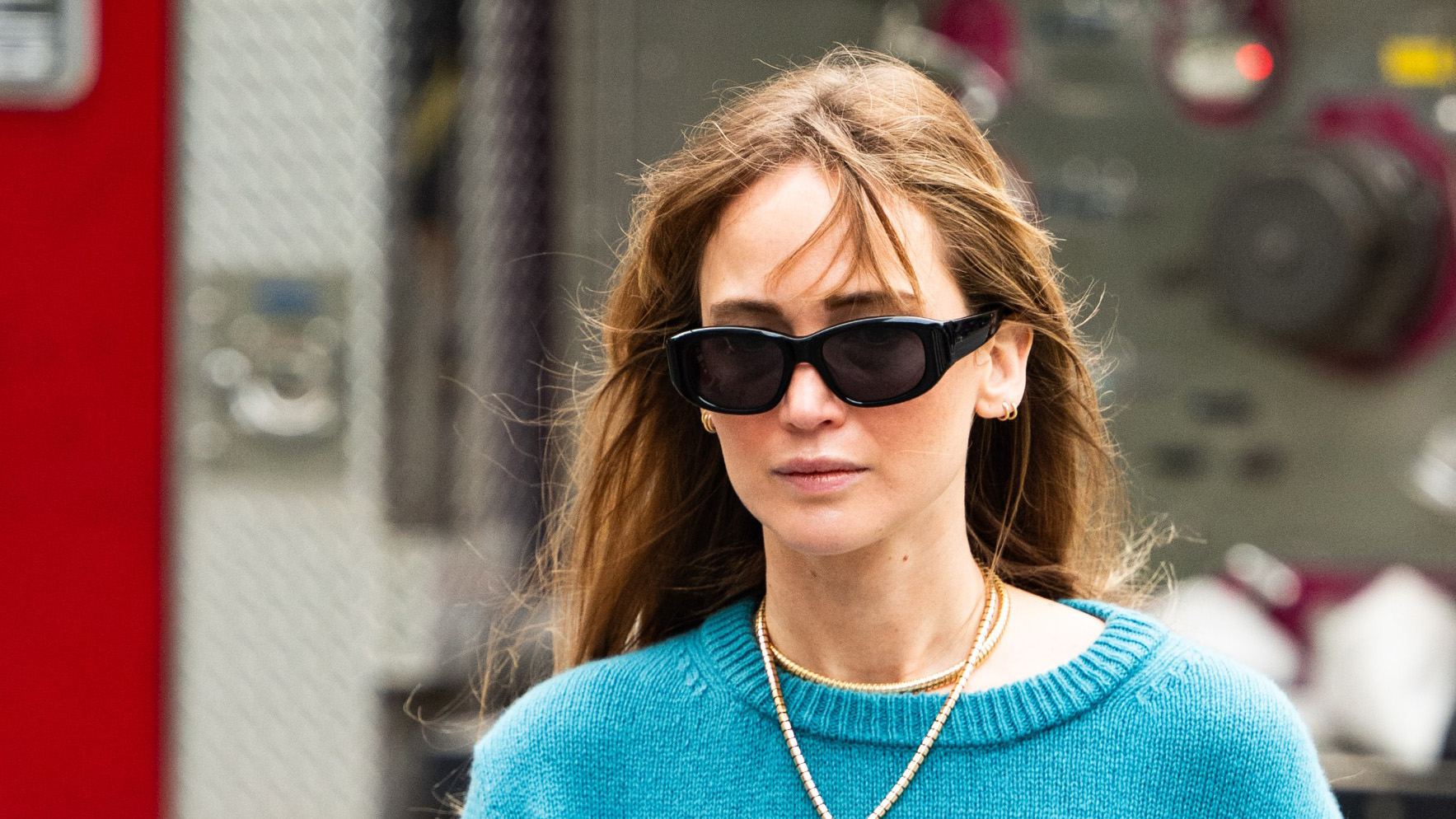 Jennifer Lawrence in NYC wearing an azure blue sweater, lariat necklace, sheer pink mini skirt, and tan boat shoes
