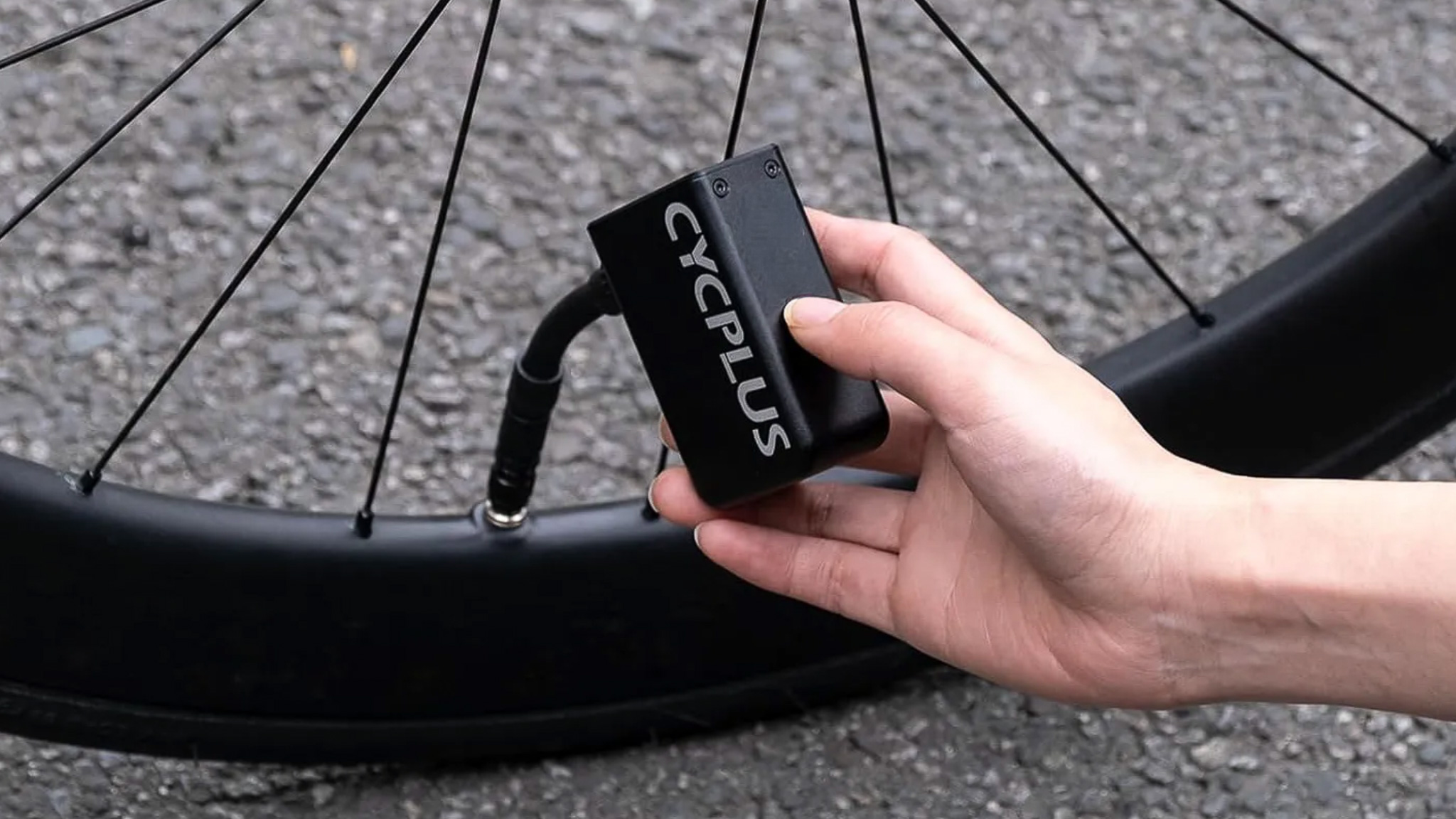 The Cycplus AS2 Electric Mini Pump being used to inflate road bike tyre
