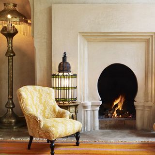room with fireplace and yellow and white printed armchair
