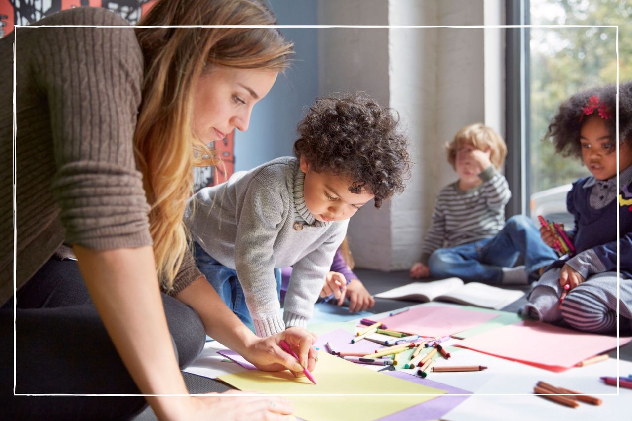 Teacher drawing with students on floor at preschool