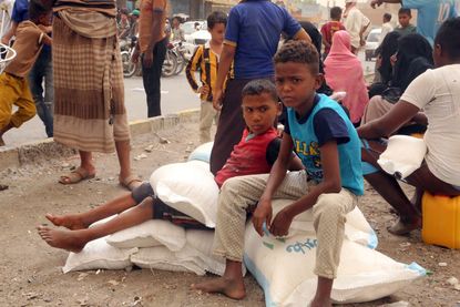 Yemeni children receive food aid in the coastal city of Hodeidah on June 14, 2018. 