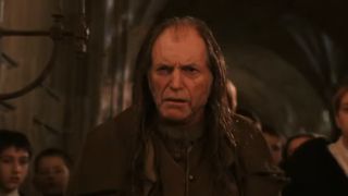 Argus Filch inside Hogwarts, about to discover Mrs. Norris has been petrified.