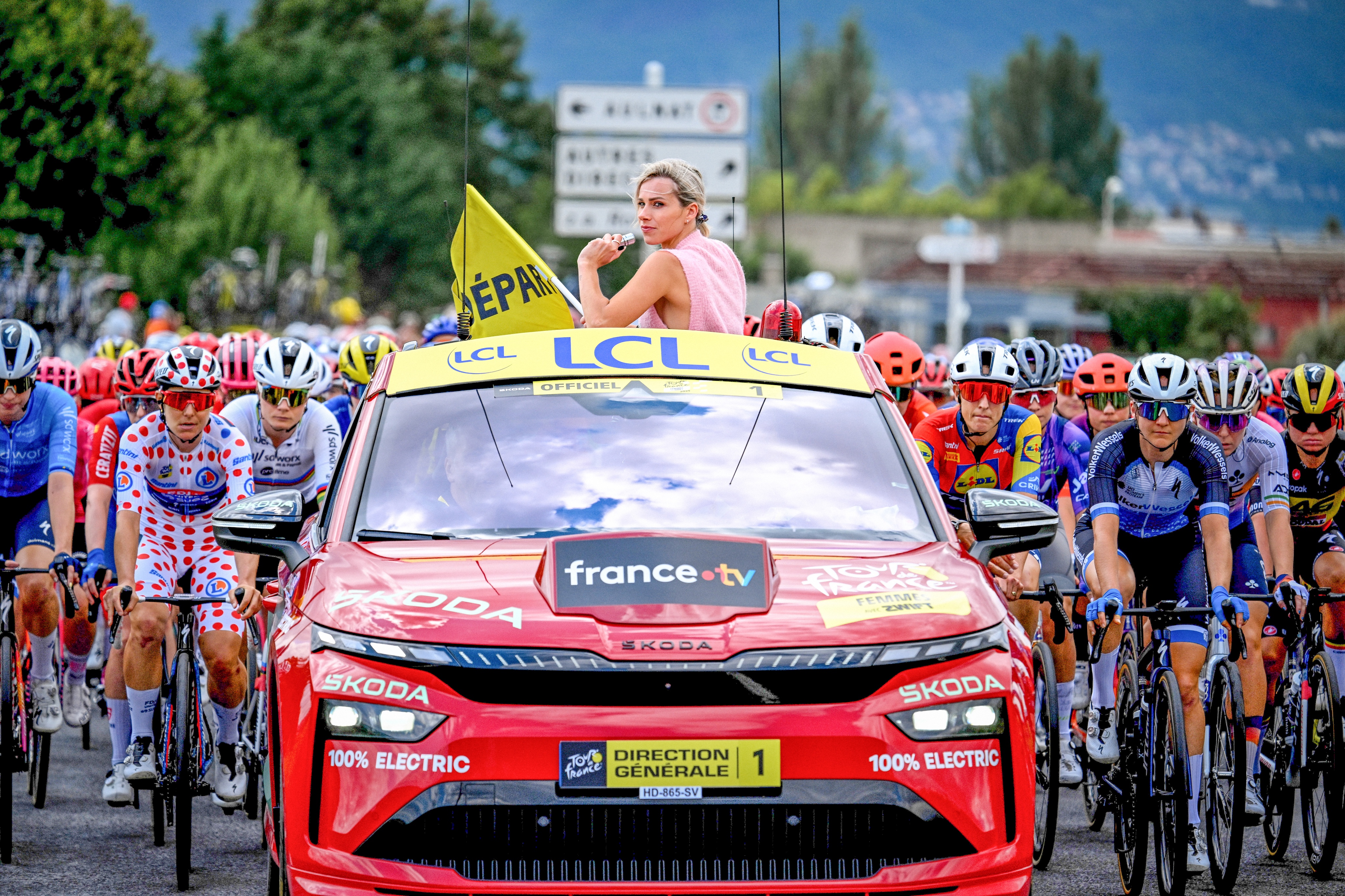 Marion Rousse out the top of a car at the Tour de France Femmes