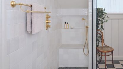 bathroom with green wall tiles, freestanding bath and gold shower