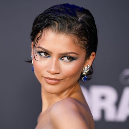 a young woman wearing blue eye makeup