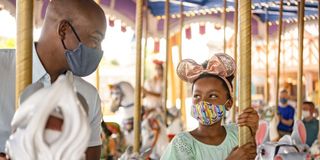 Walt Disney World guests on the carousel with masks