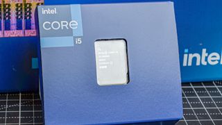 An Intel Core i5-14600K against its promotional packaging