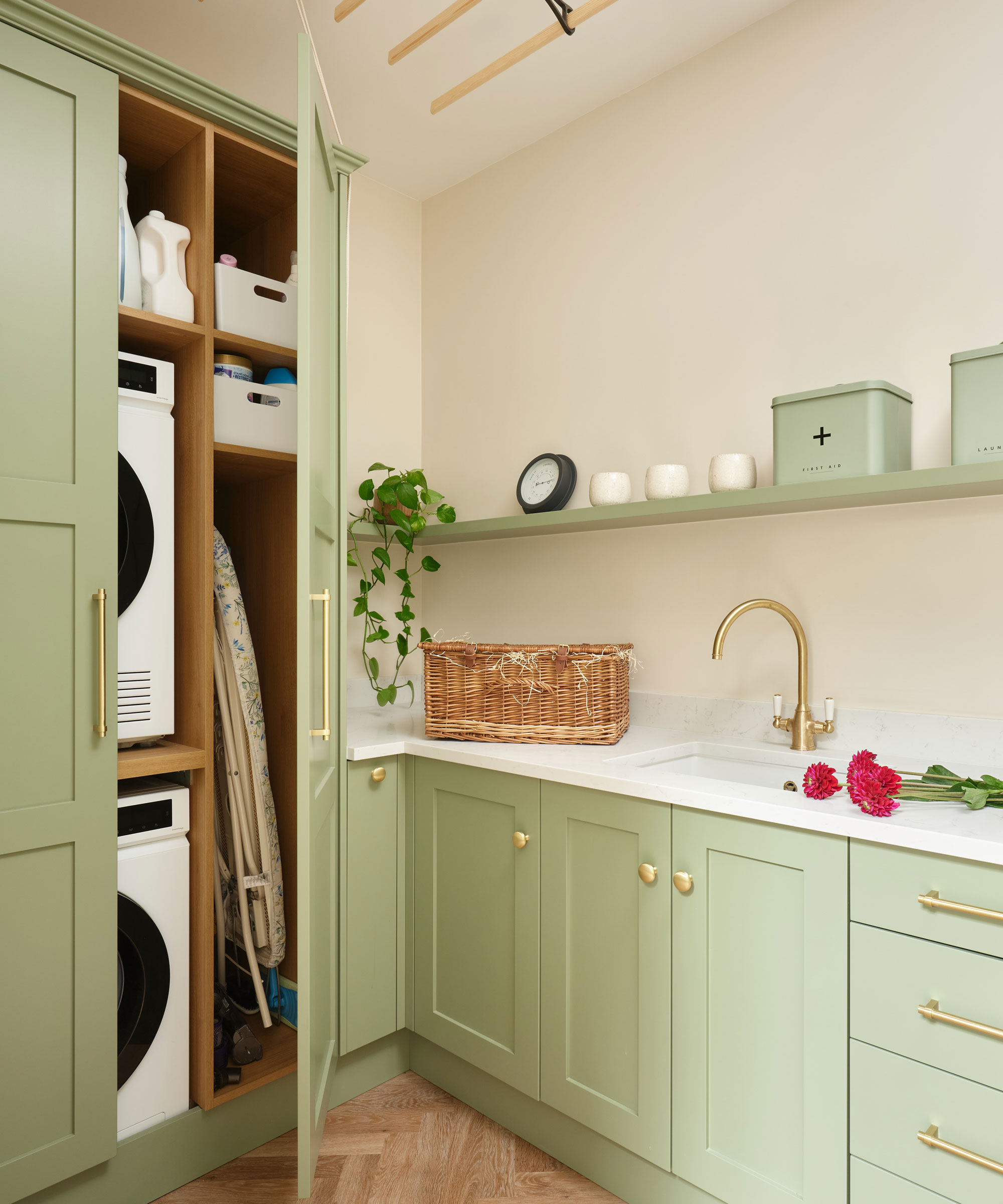 pale green Shaker utility room with tall cupboards for stacked washer and dryer