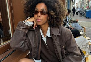 Woman in brown jacket and cardigan.