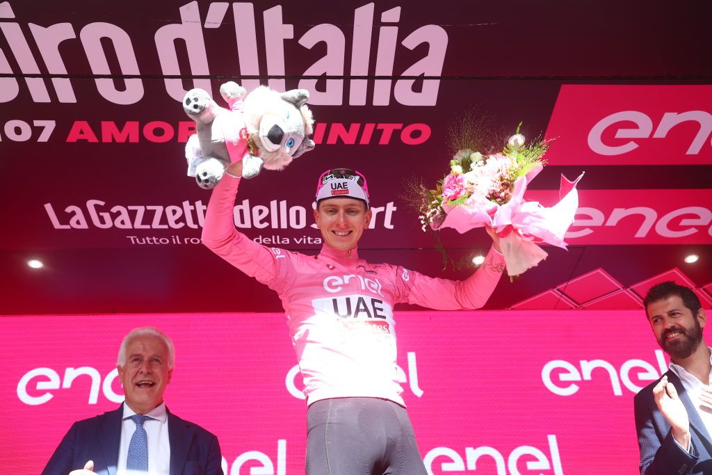 Team UAE's Slovenian rider Tadej Pogacar celebrates his overall leader's pink jersey on the podium of the 6th stage of the 107th Giro d'Italia cycling race, 180 km between Torre del lago Puccini in Viareggio and Rapolano Terme, on May 9, 2024 in Rapolano Terme. (Photo by Luca Bettini / AFP)