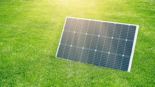 Solar panel on grass with sunlight hitting it