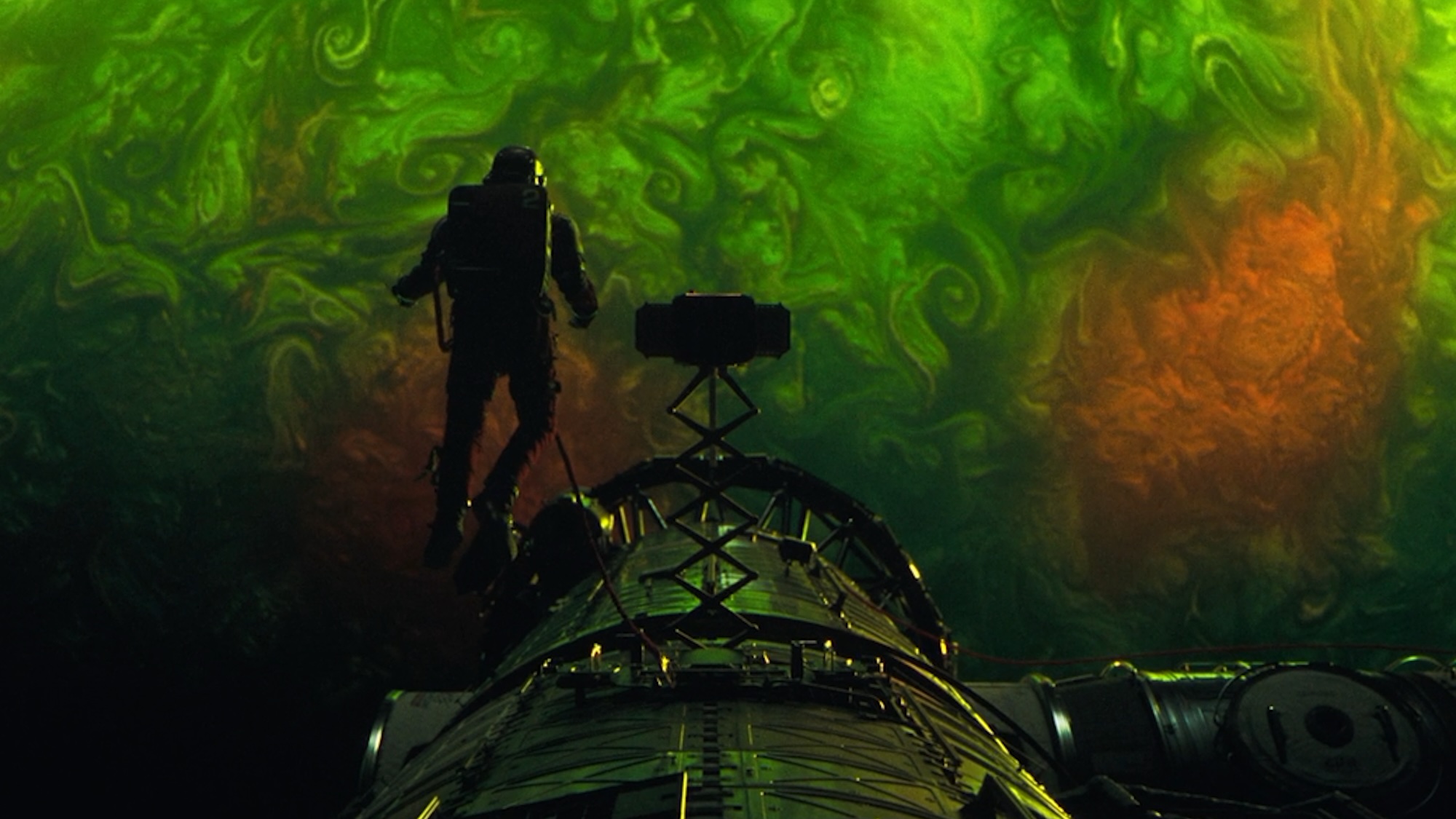 Ryland Grace in his spacesuit hovering in front of the Adrian planet in Project Hail Mary