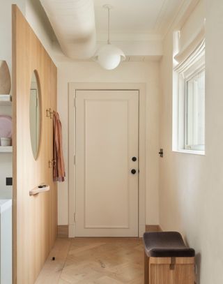 Apartment hallway with oak panelled wall featuring mirror, small shelf and coat hooks