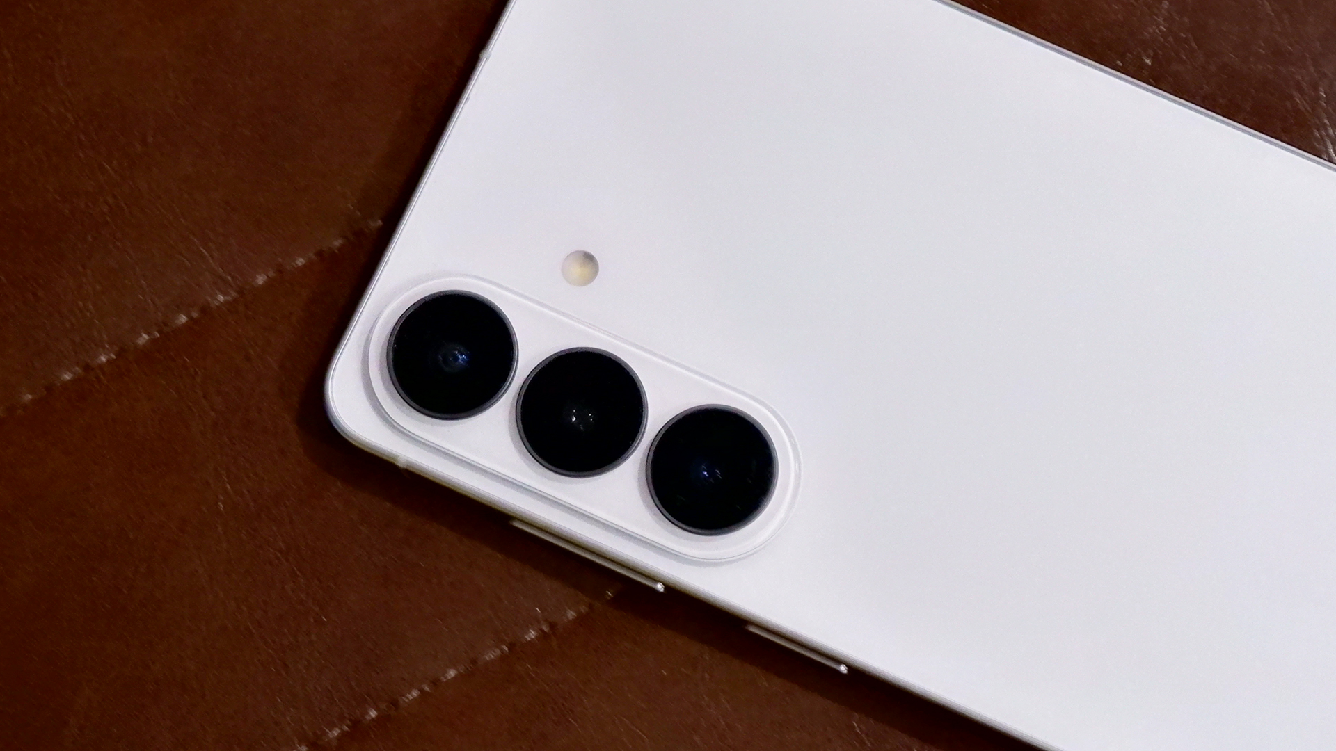 The cameras of the Samsung Galaxy S26 Plus against a brown leather background.
