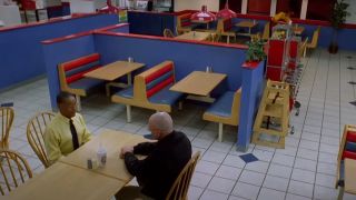 Two people sitting at a table in a fast food restaurant in Breaking Bad