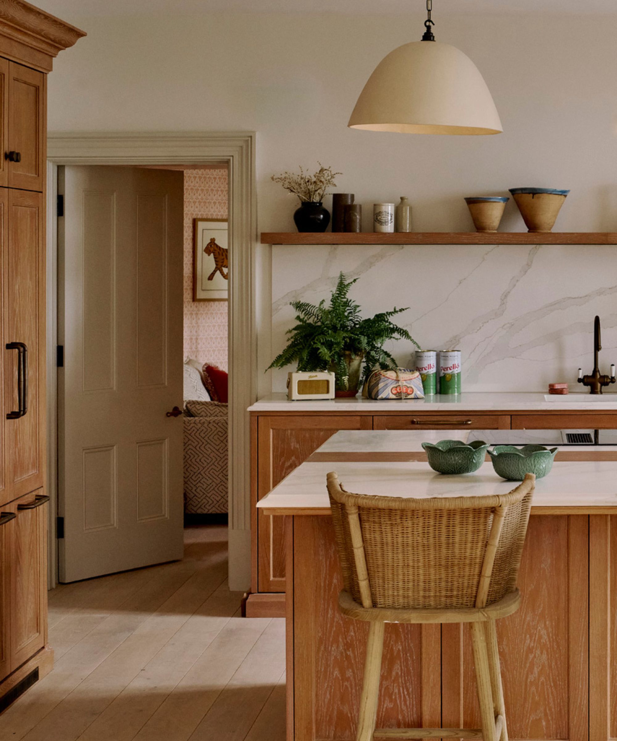 A small kitchen with wooden cabinets, white walls, and a marble countersplash